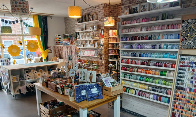 Interior of a craft store with shelves stocked with thread and supplies.